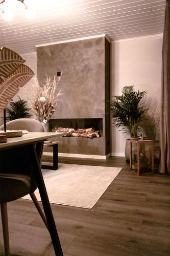 - un salon avec une cheminée et une table dans l'établissement Stylish house in the heart of Lapland in Tornio, à Tornio