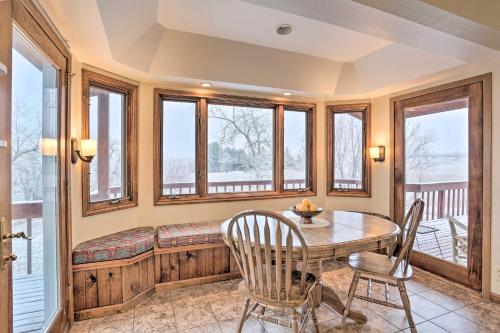 a dining room with a table and chairs and windows at Rapid City Vacation Home with Wraparound Deck! in Rapid City