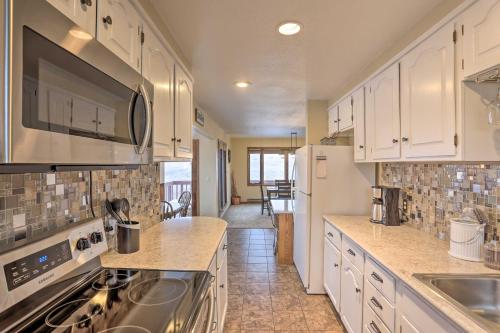 a kitchen with white cabinets and a stove top oven at Rapid City Vacation Home with Wraparound Deck! in Rapid City