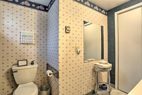 a bathroom with a toilet and a mirror at Rapid City Vacation Home with Wraparound Deck! in Rapid City