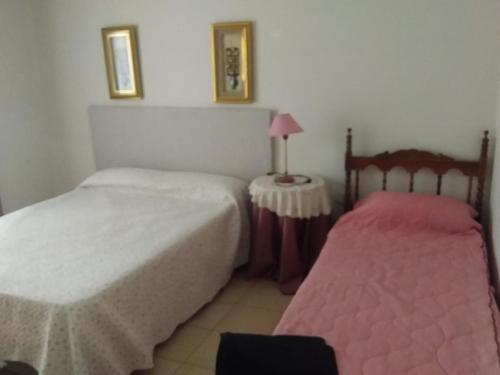 1 dormitorio con 2 camas y mesa con lámpara en Amplio Departamento en San Rafael en San Rafael