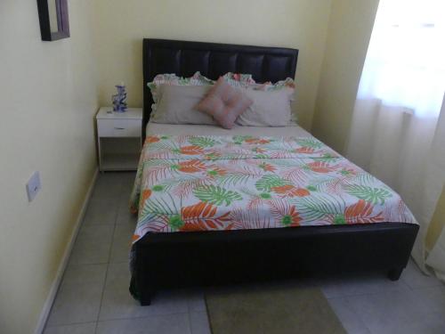 a bedroom with a bed with a black headboard at Southern Haven Guesthouse in Laborie