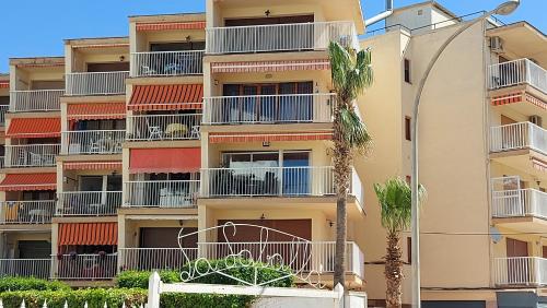 an apartment building with balconies and palm trees at BELLAMAR 25 in Cambrils