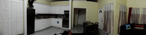 two pictures of a kitchen with white cabinets at Southern Haven Guesthouse in Laborie