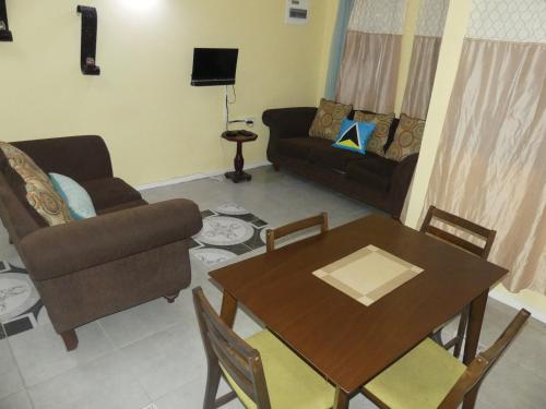 a living room with a table and a couch at Southern Haven Guesthouse in Laborie