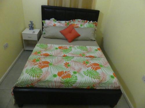 a bed with a black headboard with a flower pattern at Southern Haven Guesthouse in Laborie