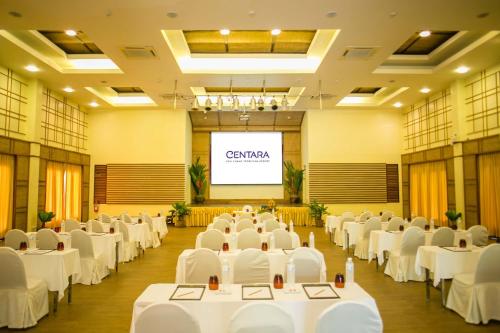 a conference room with white tables and chairs and a screen at Centara Koh Chang Tropicana Resort in Ko Chang