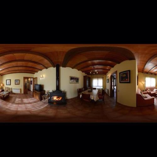 a living room with a fireplace and a living room with furniture at Las Tejas in Bayubas de Abajo