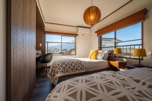 富士河口湖町にあるOriOri House Hotel Mt Fuji view 全室富士山ビューの貸切り宿 折々のベッド2台と窓が備わるホテルルームです。