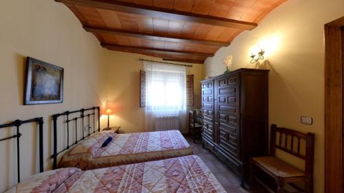 a bedroom with two beds and a wooden ceiling at Las Tejas in Bayubas de Abajo