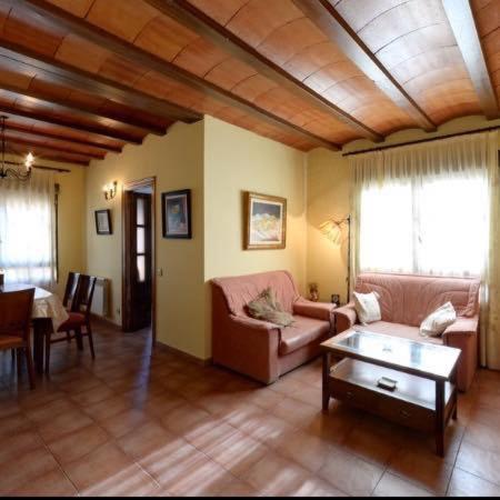ein Wohnzimmer mit einem Sofa und einem Tisch in der Unterkunft Las Tejas in Bayubas de Abajo