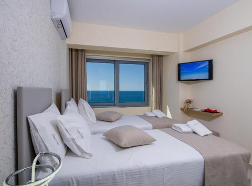two beds in a room with two large windows at Sene Villa - Sea Front in Plakias