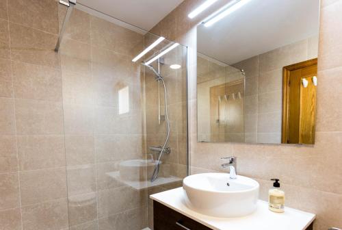 a bathroom with a sink and a shower and a mirror at CASA CON JARDIN-WIFI FREE in L'Escala