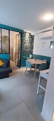 un salon avec une table et des chaises dans une pièce dans l'établissement Magnifique T2 centre ville 5 min à pieds des Arènes de Nîmes, à Nîmes