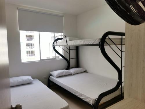 Divstāvu gulta vai divstāvu gultas numurā naktsmītnē Hermoso apartamento con piscina (alberca).