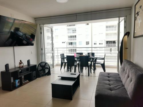 a living room with a couch and a table at Hermoso apartamento con piscina (alberca). in Girardot