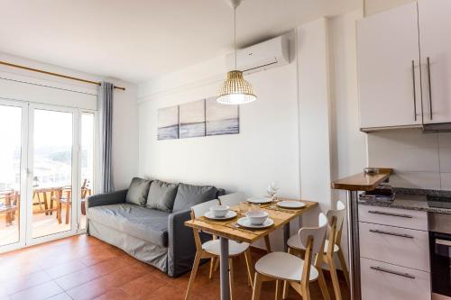 una cucina e un soggiorno con tavolo e divano di APARTAMENTO PIE DE PLAYA-Wifi free a L'Escala