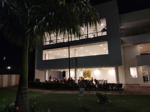 a group of people sitting outside of a building at night at Hermoso apartamento con piscina (alberca). in Girardot