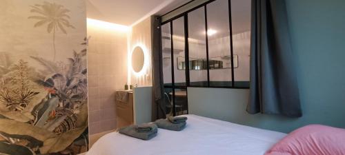 une chambre avec un lit avec deux serviettes dessus dans l'établissement Magnifique T2 centre ville 5 min à pieds des Arènes de Nîmes, à Nîmes