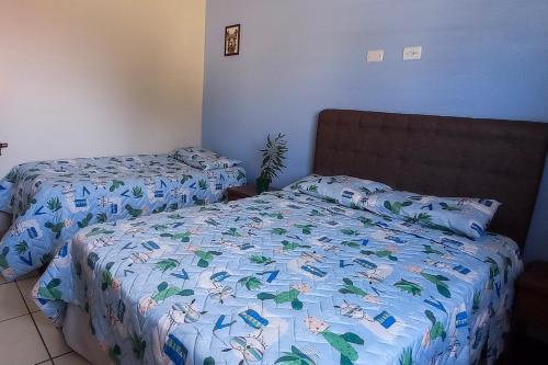 a bedroom with two beds with a blue comforter at Repouso da Cachoeira in Foz do Iguaçu