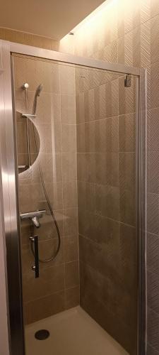 une salle de bain avec une douche avec une porte vitrée dans l'établissement Magnifique T2 centre ville 5 min à pieds des Arènes de Nîmes, à Nîmes