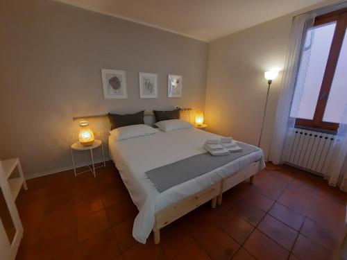 a bedroom with a large white bed with two lamps at Contrada d'Amore in Angera