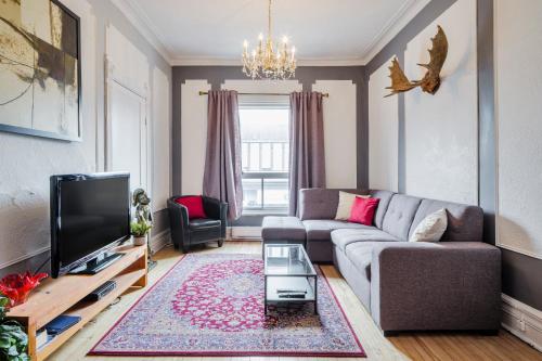 a living room with a couch and a tv at MtlVacationRentals - Appartements Plateau-Mont-Royal in Montréal