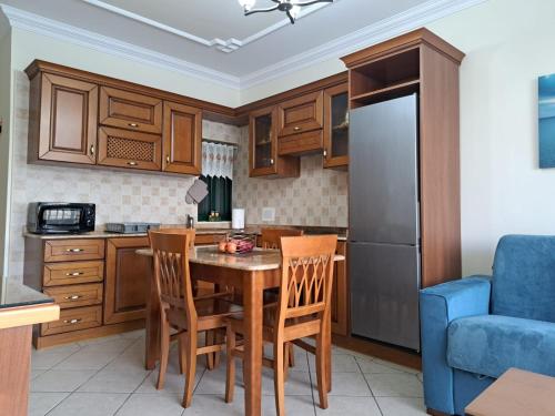 a kitchen with a table and chairs and a refrigerator at Seafront Apartment in St. Paul's Bay in St Paul's Bay