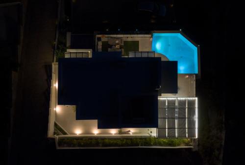 an aerial view of a house with a swimming pool at night at Sene Villa - Sea Front in Plakias