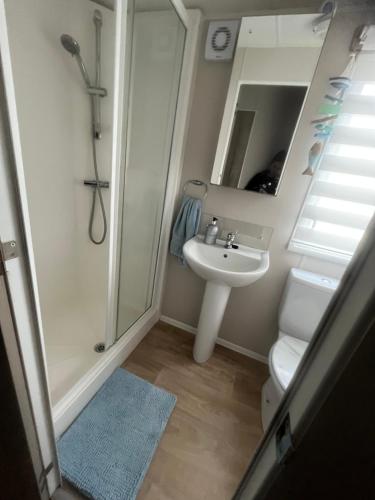 a bathroom with a sink and a shower and a toilet at Sky by the sea in Whitstable