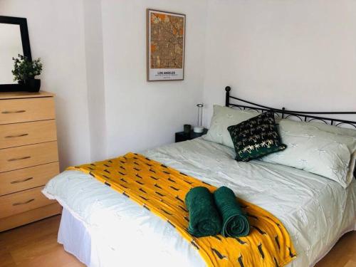 a bedroom with a bed with green towels on it at Cosy House, Lisburn Road in Belfast