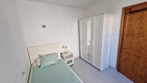 アリエタにあるCheladaの白いベッドルーム(ベッド1台、木製のドア付)