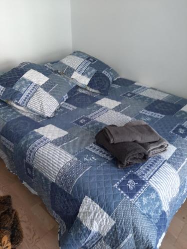 a bed with a blue and white quilt on it at charmant appartement en plein coeur de Trouville in Trouville-sur-Mer