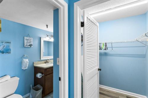 a bathroom with blue walls and a toilet and a sink at 403 Beach Place Condos in St. Pete Beach