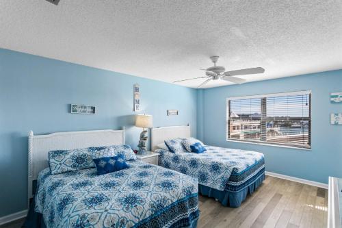 a bedroom with two beds and a ceiling fan at 403 Beach Place Condos in St Pete Beach