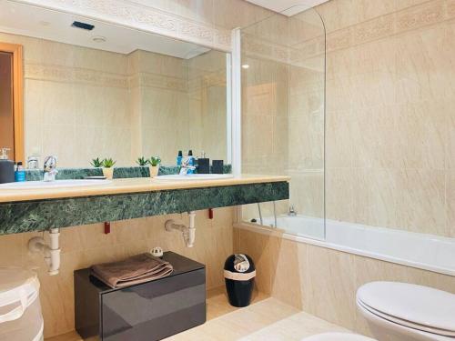 La salle de bains est pourvue de toilettes, d'un lavabo et d'une douche. dans l'établissement Blue Palm Apartment Estepona, à Estepona