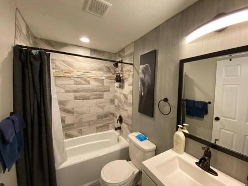y baño con bañera, aseo y lavamanos. en High Quality 3200sqft House, Pool Table, Laundry, en Murray