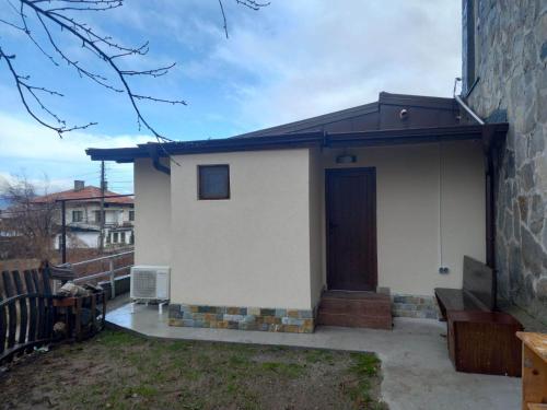 a small white house with a brown door at Къща за гости Елит (Guest House Elite) in Sapareva Banya