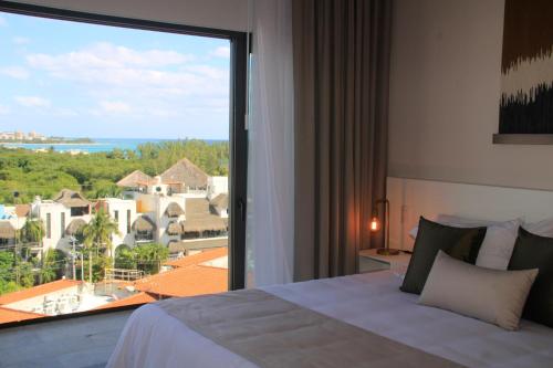 Schlafzimmer mit einem großen Fenster mit Aussicht in der Unterkunft Singular Dream Vacation Rentals in Playa del Carmen