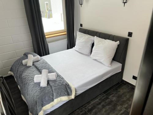sypialnia z łóżkiem z dwoma krzyżykami w obiekcie Apartamenty Slowianka w mieście Wolibórz