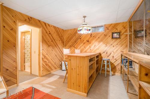 a wood paneled kitchen with a table and a stool at The River Retreat in Thompsonville