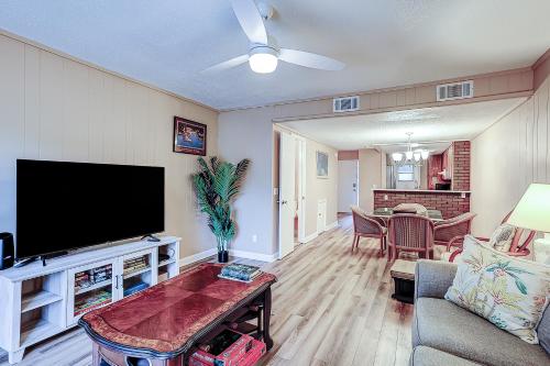 a living room with a flat screen tv and a table at Hilton Head Cabanas 14 in Hilton Head Island