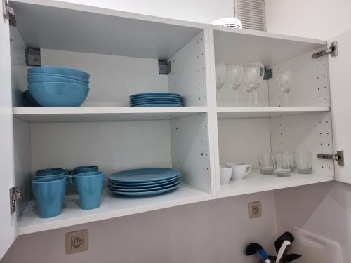 a kitchen shelf with blue plates and bowls on it at Florya Studio Woluwe in Brussels