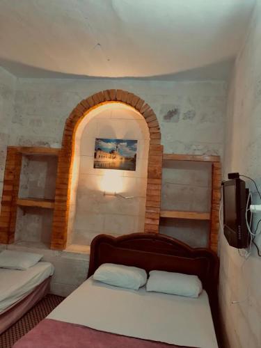 a bedroom with two beds and an arched window at Alkan konuk evi in Urfa