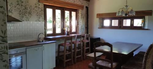 a kitchen with a table and a sink and a table at Casavieja Rural in Abiada