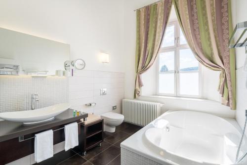 a bathroom with a tub and a sink and a toilet at Schloss Thurnau in Thurnau