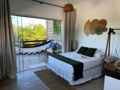 a bedroom with a bed and a sliding glass door at Flats Corumbau in Corumbau