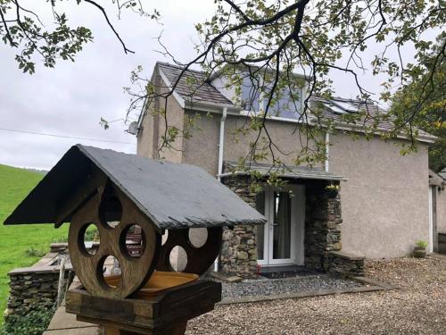 a bird house sitting in front of a house at Tudor Cottage, Newby Bridge in Ulverston