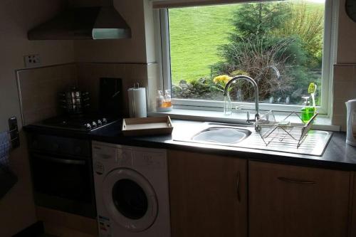 um balcão de cozinha com um lavatório e uma janela em Tudor Cottage, Newby Bridge em Ulverston