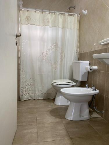 y baño con aseo y cortina de ducha. en monoambiente GUALEGUAYCHÚ centro en Gualeguaychú